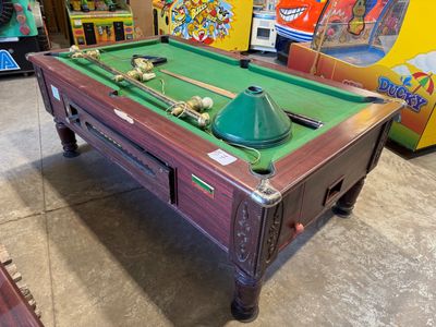 une table de billard recouverte d'un tapis vert, dans une pièce