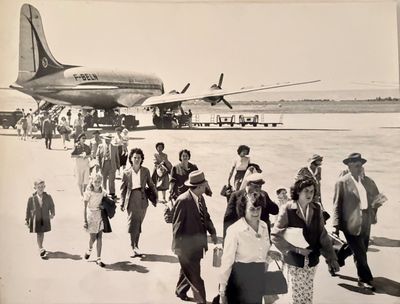 many people that are walking towards an airplane on the tarmac