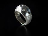 a close up of a silver ring on a black surface