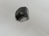 un gros plan d'un diamant noir sur une surface blanche