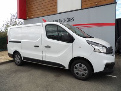 La camionnette blanche est garée devant un immeuble dans la rue.