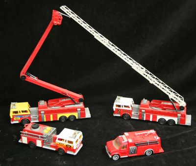 quatre camions de pompiers miniatures et une grue sur fond noir