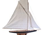 a wooden model of a sailboat with a white sail