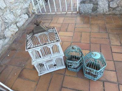 deux cages à oiseaux posées par terre l'une à côté de l'autre