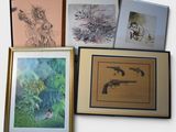 a lot of framed art on the wall of this room