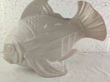 a white ceramic fish that is sitting on a table