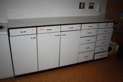 une armoire blanche avec des tiroirs dans une pièce