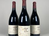 trois bouteilles de vin sont alignées sur une table