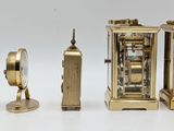 three clocks sitting next to each other on a white surface