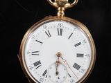 a gold pocket watch with roman numerals on it