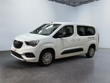 La camionnette blanche est garée dans une grande pièce au sol gris.