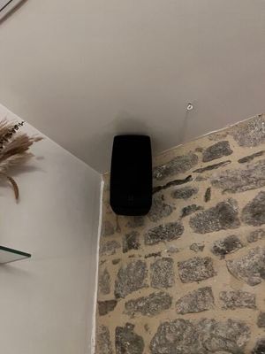 un vase avec des fleurs posé sur une étagère dans un coin de la pièce
