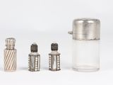 three silver salt and pepper shakers and a glass container