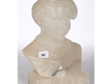 a white marble bust of a woman with a hat on top of it