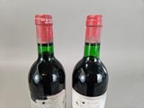 two bottles of wine sitting next to each other on a table