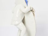 porcelain figurine of a man carrying a surfboard on a pink base