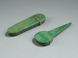 two small green objects on a white surface
