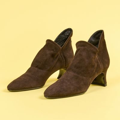 une paire de bottines en daim marron sur fond jaune