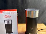 une brique de lait et une cafetière posées sur une table