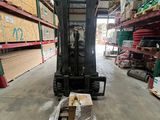 a forklift in a warehouse with a lot of boxes on the floor