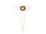 a close up of a gold and black flower broochle