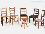 Plusieurs chaises et tabourets en bois sont alignés sur un fond blanc.