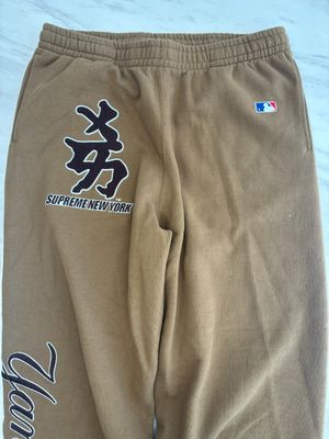 brown sweat pants with chinese characters on them on a bed