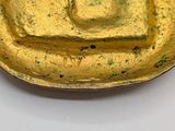 a gold plate with a square on it on a table