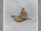 a white marble plate with a gold bird on it