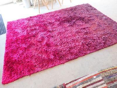 un tapis rose posé sur le sol du salon