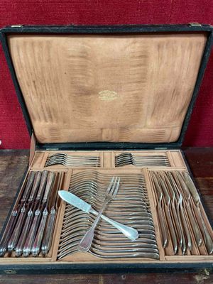 un coffret en bois contenant de l'argenterie sur une table
