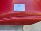a red suitcase with a sticker on it sitting on the ground