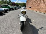 a white motorcycle parked in front of a brick building