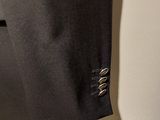 a close up of a black suit on a hanger