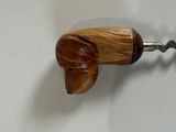 a wooden dog shaped bottle opener hanging on a wall