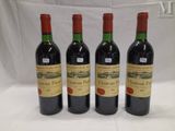 three bottles of red wine are lined up on a table
