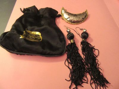 un sac noir sur lequel est accrochée une paire de boucles d'oreilles