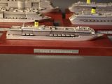 three model ships that are on display on a table