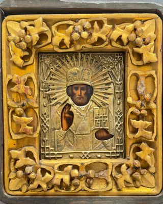 un cadre photo ouvragé, doré et noir, représentant Jésus