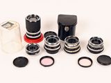 an image of a group of cameras and lenses on a white surface