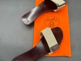 pair of brown leather shoes with orange pouch on grey surface