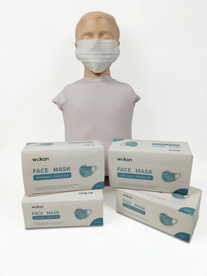 trois boîtes de masques sont posées à côté d'une tête de mannequin