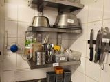 a kitchen with a sink and shelves with pots and pans on it