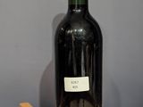 a bottle of wine sitting on top of a wooden barrel