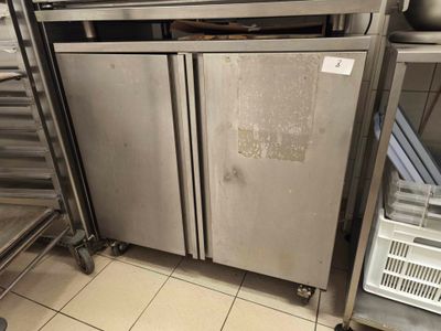 stainless steel double door refrigerators in a commercial kitchen with stainless steel shelves