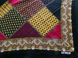 a close up of a red, yellow, and black scarf on a black background