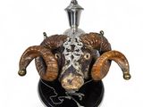 un objet argenté et noir orné d'une tête de bélier