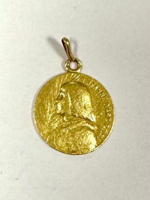 gros plan d'une médaille d'or sur une surface blanche
