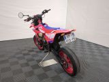 a red and white motorcycle parked on a black and white checkered floor