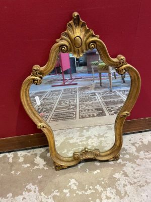 un miroir posé par terre devant un mur rouge